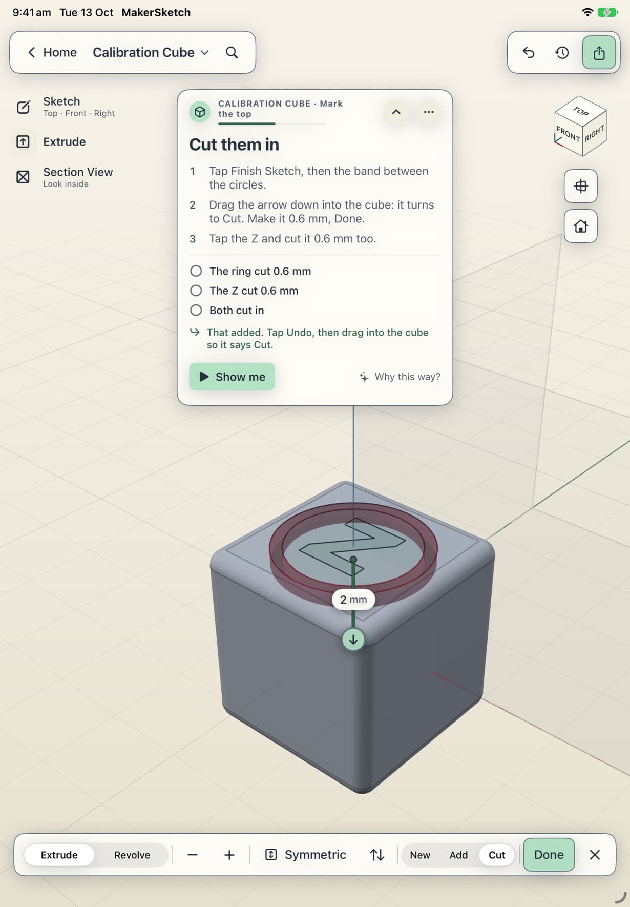 Cutting the ring into the cube: the extrude arrow points down and the coach card says “That added. Tap Undo, then drag into the cube so it says Cut.”